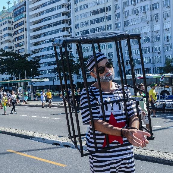 Man in pretend jail in parade in Brazil