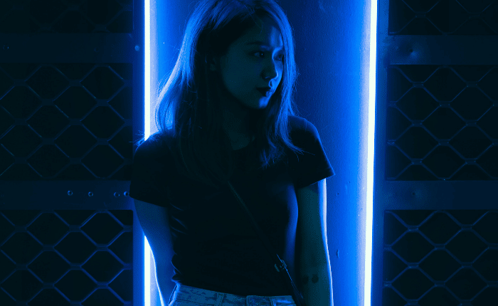 portrait of a woman illuminated by neon blue light