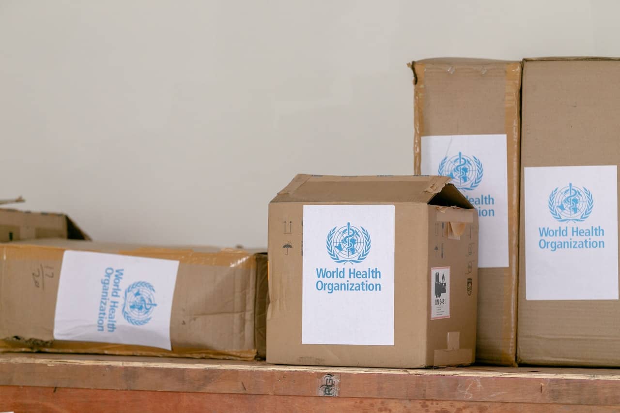 cardboard boxes with world health organisation stickers