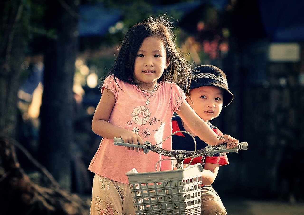 two kids riding a bike