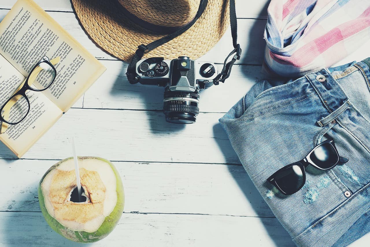 a book camera sunglasses and a coconut