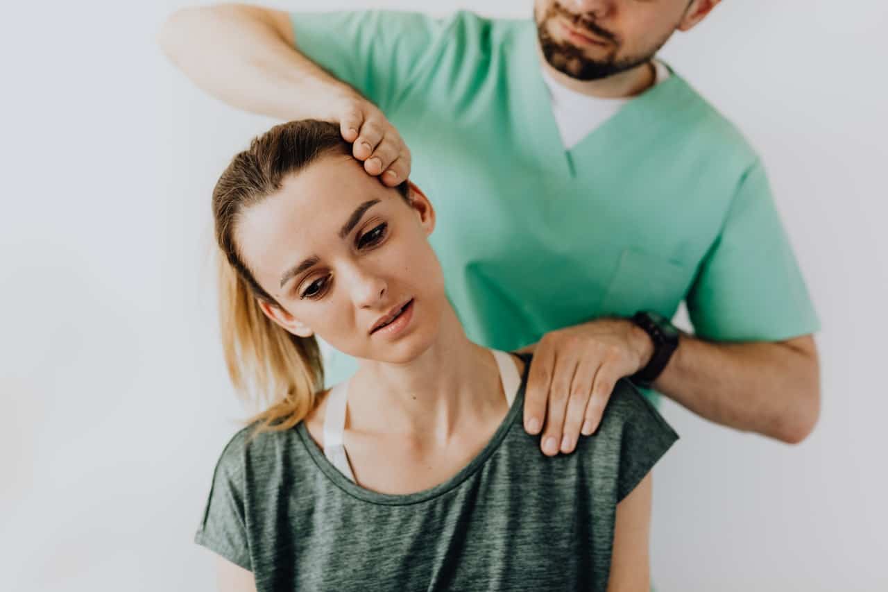 doctor examining a patient by tilting her head