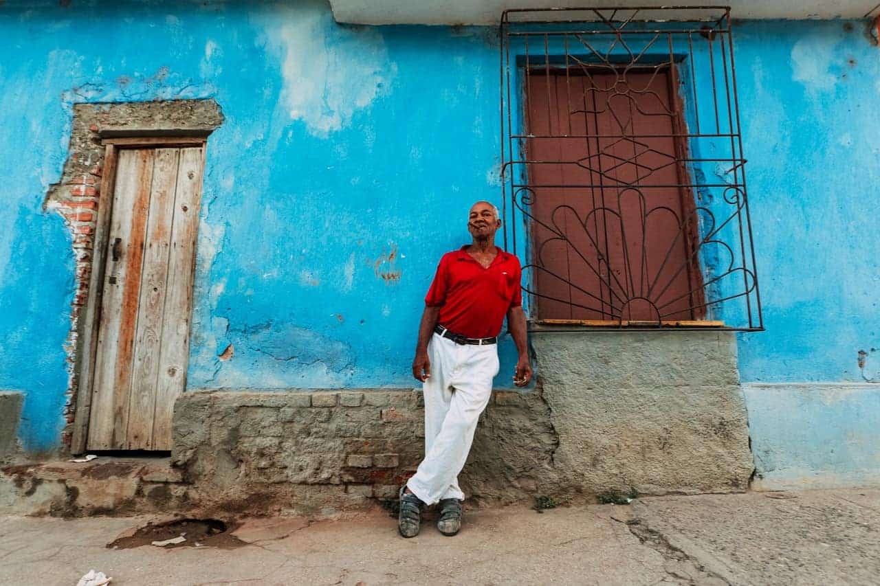 man standing in front of a bright blue building