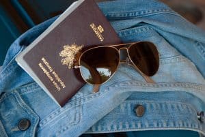 jean jacket with sun glasses and Passport