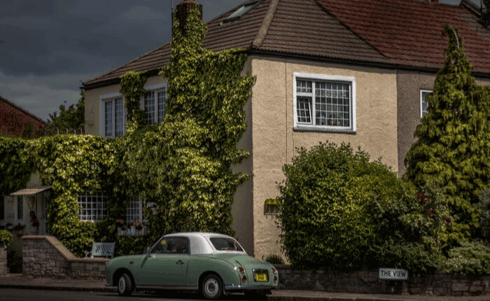 old house with green car on front