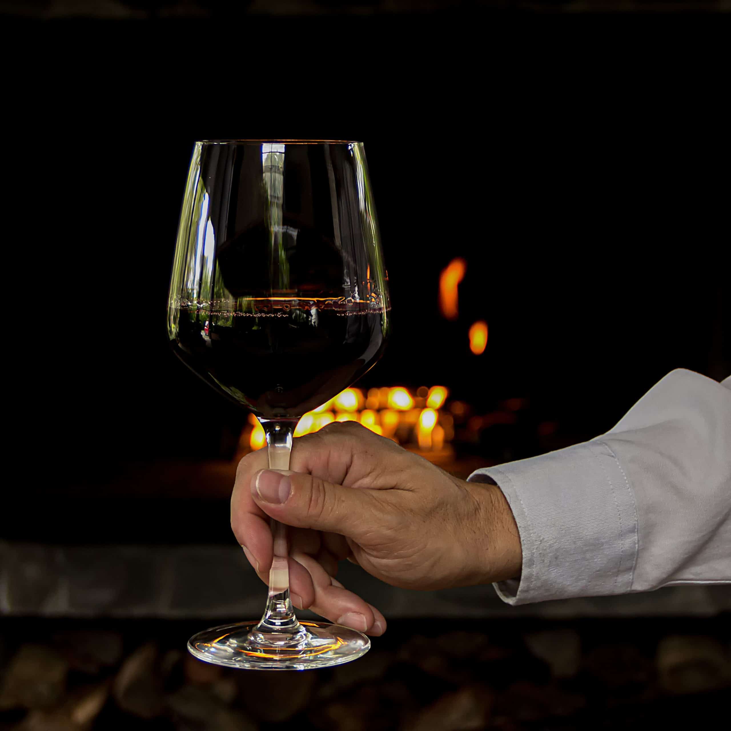 man holding a glass of red wine