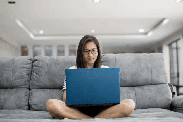 Girl sitting on sofa with laptop