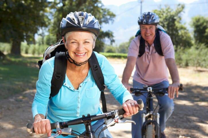 retirees with a smile on their faces, riding their bikes