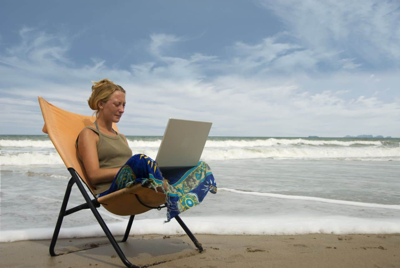 young woman using notebook at the beach