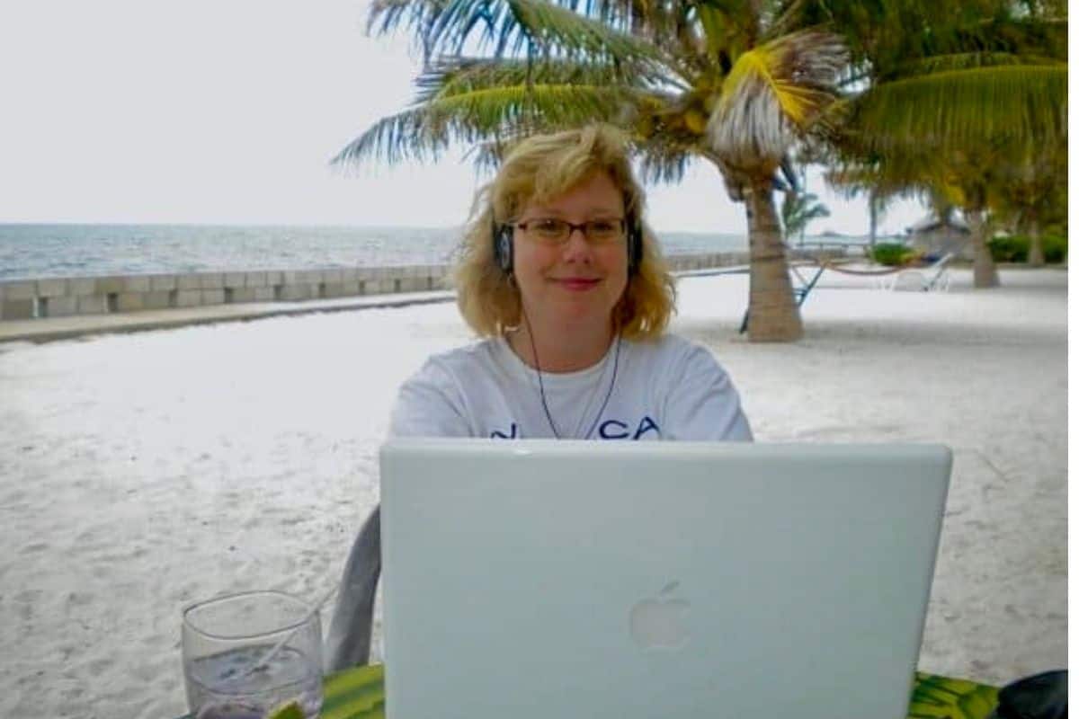 Woman working on the beach with her laptop in Belize