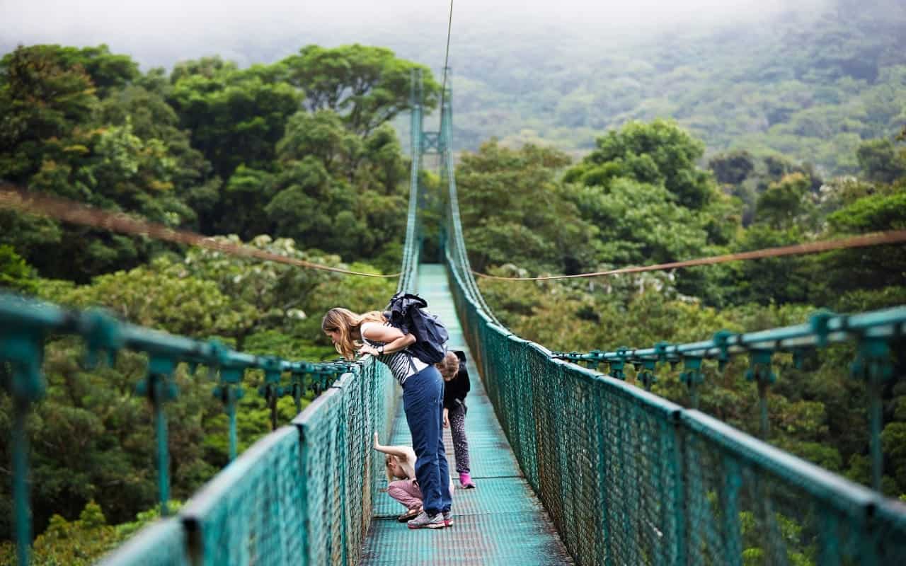 2 girls and a child on a suspension bridge in Costa Rica