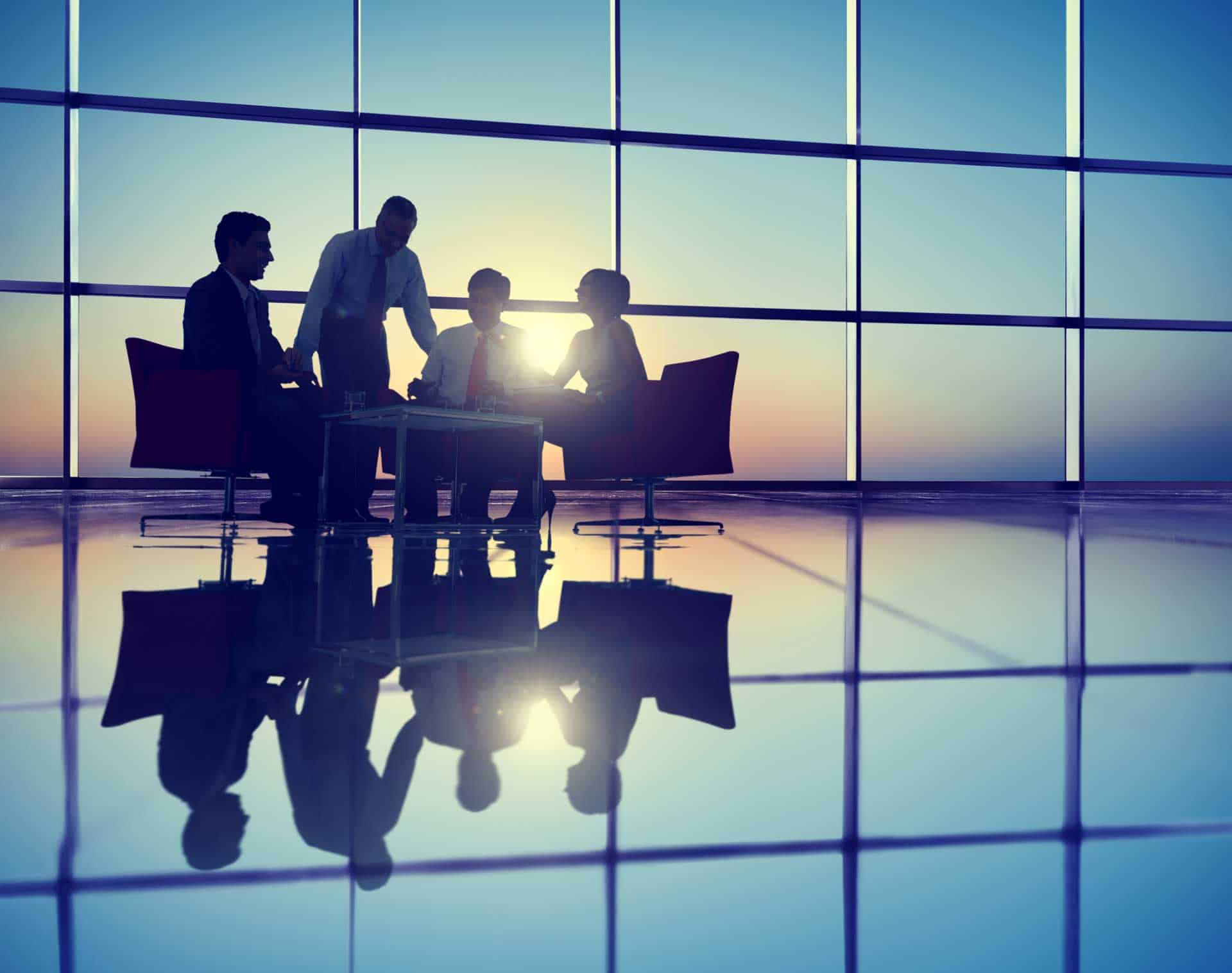 people around a desk with a sun set in the back ground