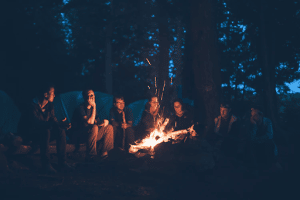 Young people around a camp fire in the evening