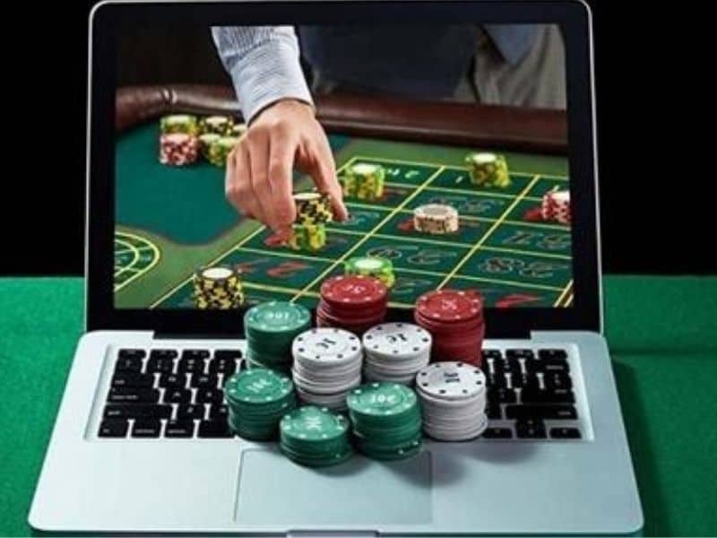 man's hand coming through the computer for casino chips