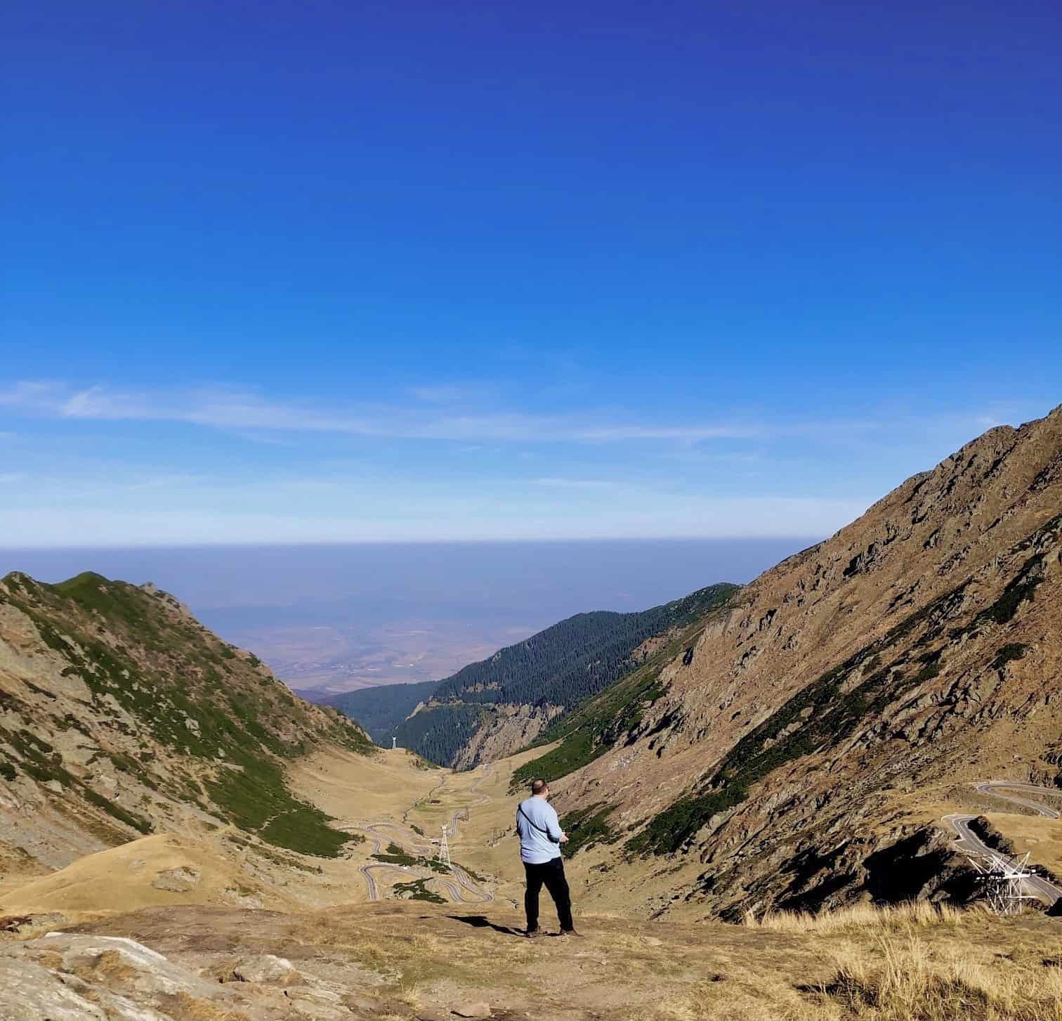 Man in a valley overlooking the mountains