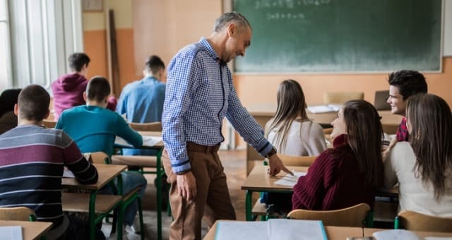 man standing teaching students