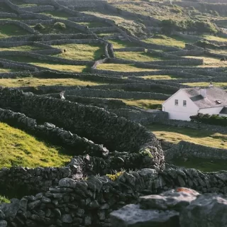 Rolling emerald fields and soft skies in County Kerry.