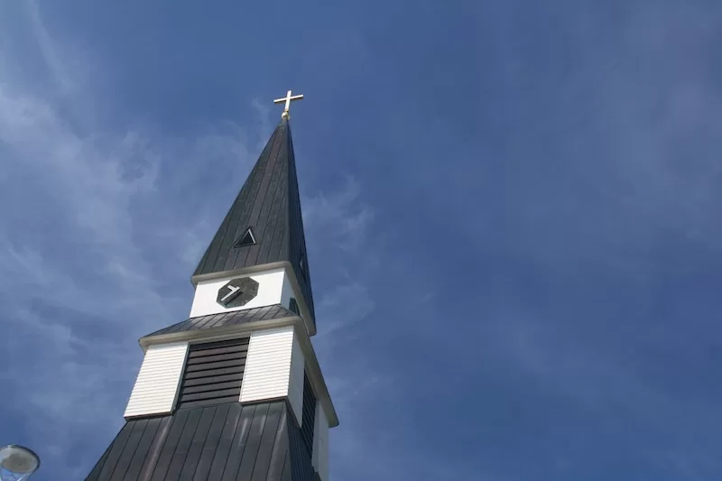 The spire of Rovaniemi Church rises against an unbroken blue sky