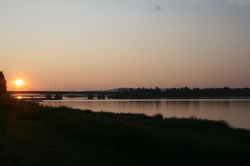 Near midnight, the sun hovers on the horizon above the Kemijoki River