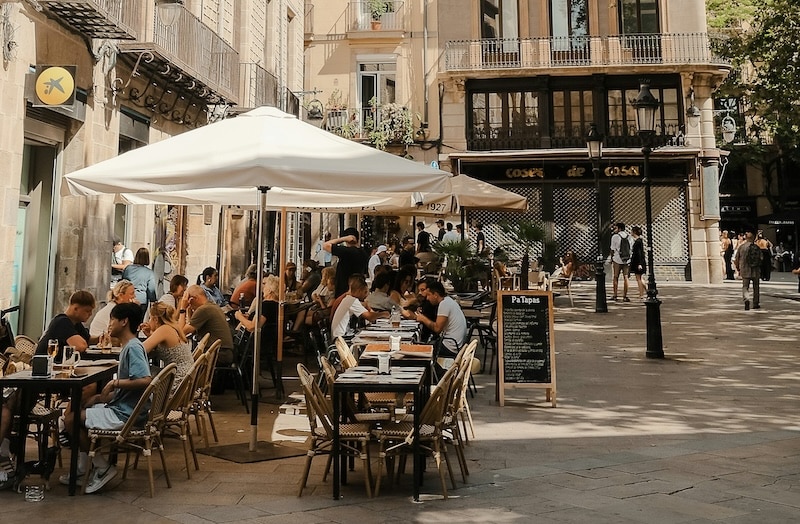 Outdoor cafés in a Spanish plaza, the perfect place to enjoy a menú del día, one of Spain’s best-value dining traditions with full meals for under €15.