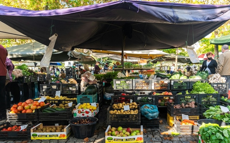 Local farmers’ stalls show why food costs stay low in Portugal: short supply chains, peak-season produce, and plenty of choice.