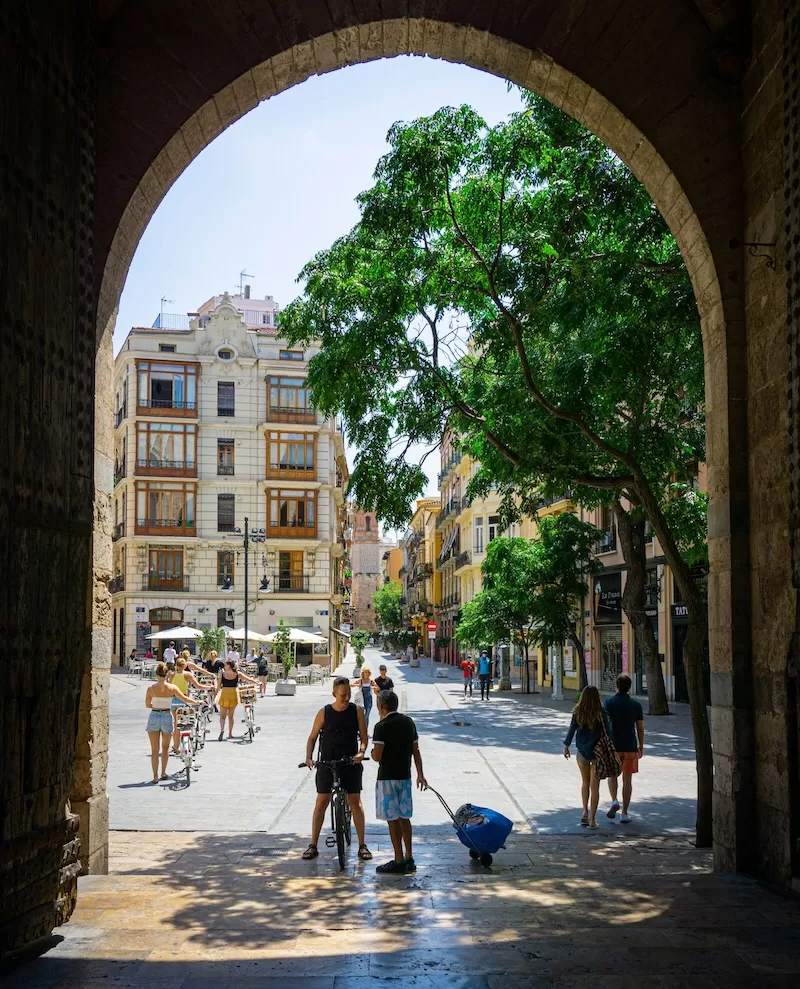 Valencia on a typical morning: neighbors chatting, cyclists weaving through sunlight, and the kind of easy routine that makes belonging feel effortless.