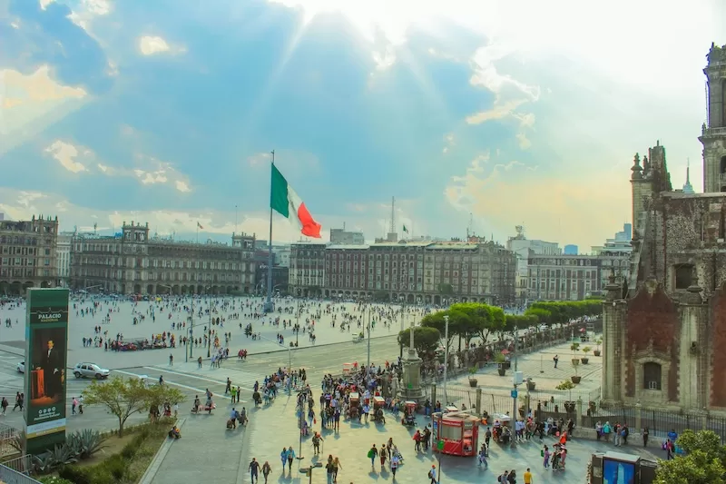 Afternoon light over Mexico City’s Zócalo, where the national flag towers above centuries of history, merging colonial architecture with the beat of modern urban life.
