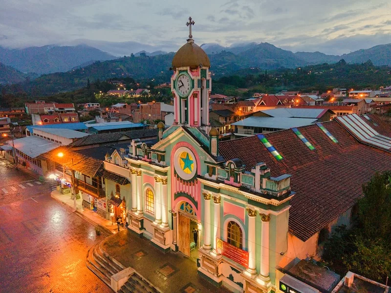 Evening light falls over a parish church in southern Ecuador. Across the Andes, Catholicism blends with older Indigenous beliefs, creating celebrations that honor both saints and spirits, sky and earth.