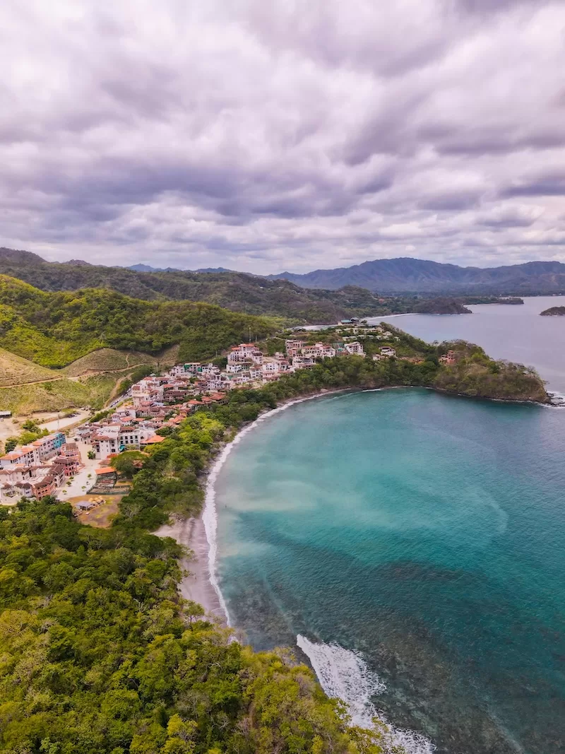 Aerial view of Guanacaste’s Pacific coast, where golden beaches meet emerald hills and expat communities thrive in towns like Tamarindo, Playas del Coco, and Flamingo.