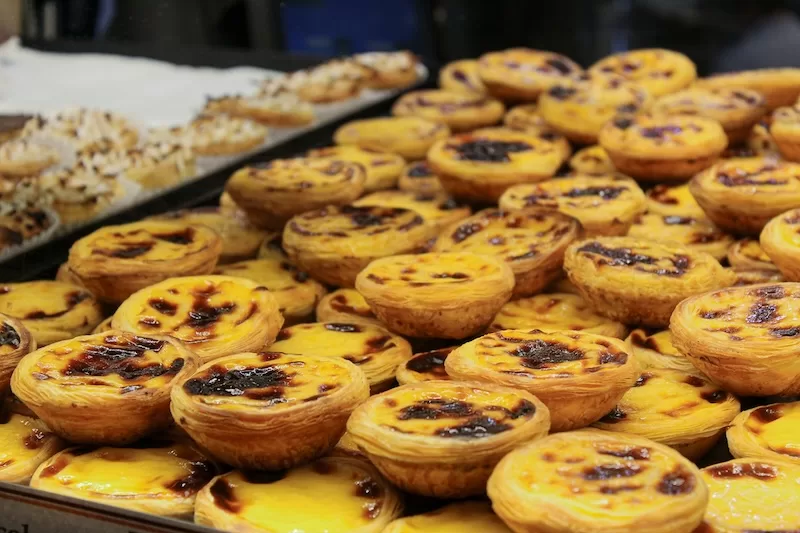 A tray of freshly baked pastéis de nata, Portugal’s iconic custard tarts that prove small luxuries don’t have to come with a big price tag.
