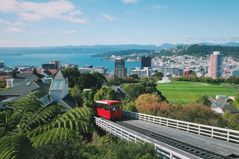 A red cable car climbs toward Kelburn, showing how Wellington blends daily life with postcard views, and why public transport often beats driving.