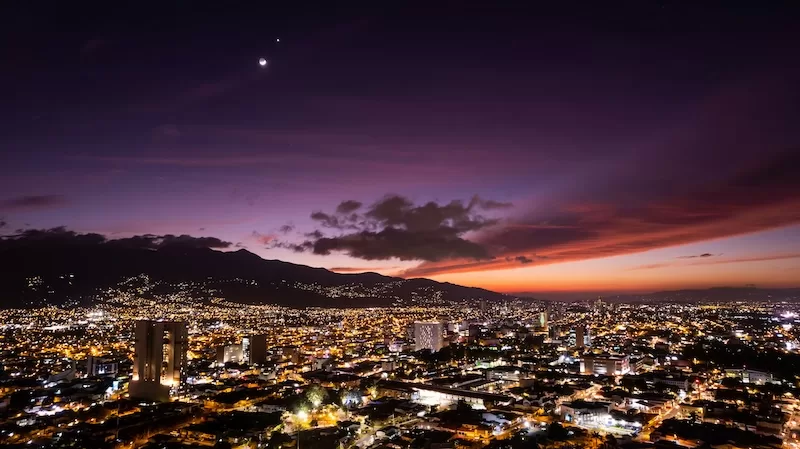 San José’s skyline glows under a purple dusk, a reminder that every neighborhood in Costa Rica has a different rhythm once the sun sets. Visiting at night helps renters understand the real pace, energy, and atmosphere of their future home.