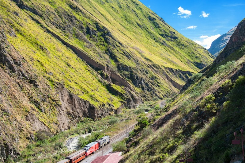 A train snakes through the steep green canyons near Riobamba, tracing the legendary Nariz del Diablo route. 