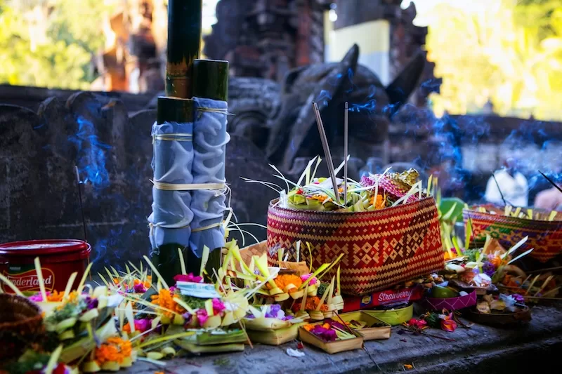 Incense curls into the warm morning air while petals brighten the stone. Tiny offerings mark a new day in Bali, reminding you that life here keeps one foot in ritual and one in everything happening around it.
