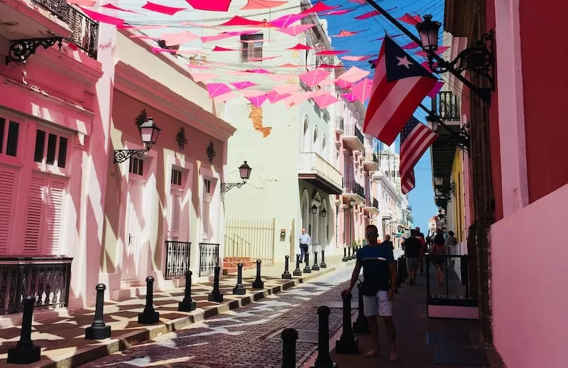 Old San Juan’s pastel streets blend history and familiarity. U.S. flags hang beside Puerto Rican ones, a sign that life here moves between two worlds.
