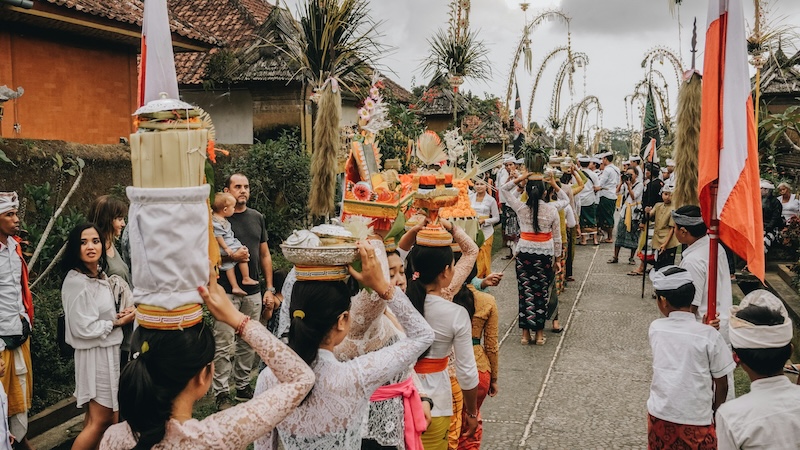 A procession turns an ordinary street into a moving tapestry of flowers, drums and shared purpose. In Bali, tradition is not something you visit. It walks right past your doorstep.