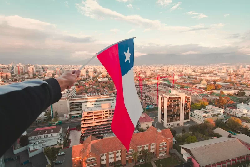 Santiago looking toward the Andes as the flag lifts. September turns the capital into a dance floor where the celebration never feels far away.
