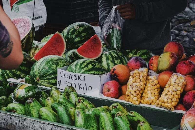 Growth and color piled into crates at sunrise. This is where expats learn how far their money can go.