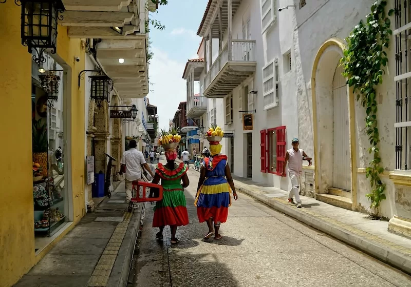 Street vendors in Cartagena carry fruit through the city’s historic center, a reflection of Colombia’s informal economy, where families balance tradition, entrepreneurship, and urban adaptation.