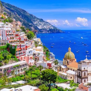 Colorful cliffside village of Positano Italy with pink and white buildings overlooking Mediterranean Sea showing Mediterranean charm for expats relocating