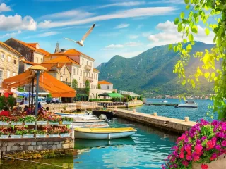 Aerial view of Montenegro's Adriatic harbor with yacht marina and mountain backdrop, representing Montenegro's appeal as a small country expat destination with European optionality