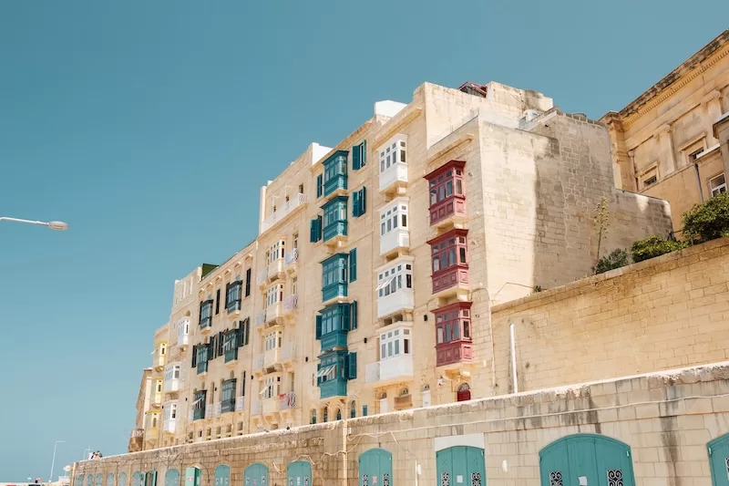 Coastal view of Valletta, Malta with historic buildings overlooking turquoise Mediterranean waters, representing Malta's appeal as a small country expat destination with Mediterranean lifestyle