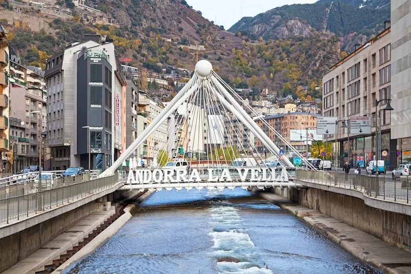 Modern bridge structure in Andorra La Vella crossing river with mountain backdrop, showcasing Andorra's modern infrastructure and appeal as a small country for expats