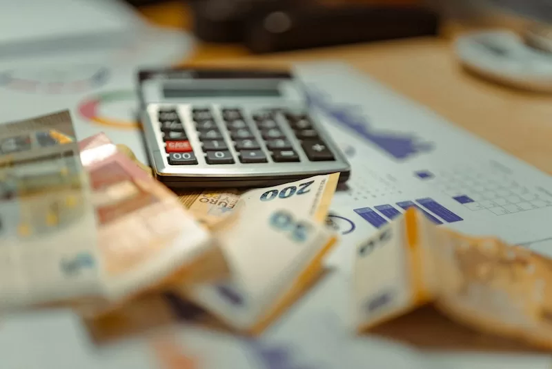 Calculator and euro banknotes on financial documents showing tax planning and low-tax living strategy for expats abroad