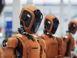 Humanoid robots lined up in an industrial facility, representing artificial intelligence technology and automation innovations discussed in global news trends