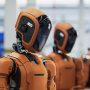 Humanoid robots lined up in an industrial facility, representing artificial intelligence technology and automation innovations discussed in global news trends