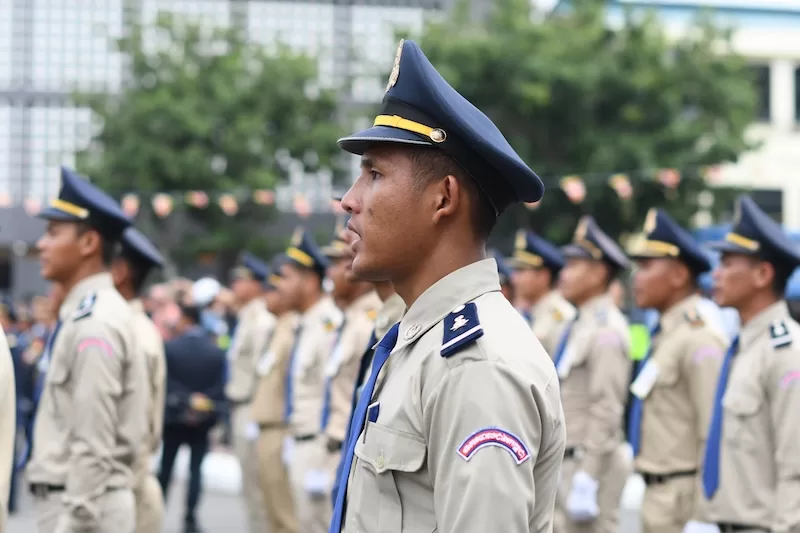 Military officer in uniform standing at attention with armed forces formation in background, representing regional military tensions and border conflicts between nations
