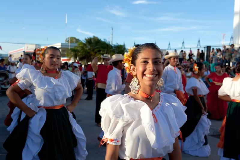 Young woman in traditional Costa Rican dress with flowers and jewelry at cultural festival, celebrating local traditions and community cultural events