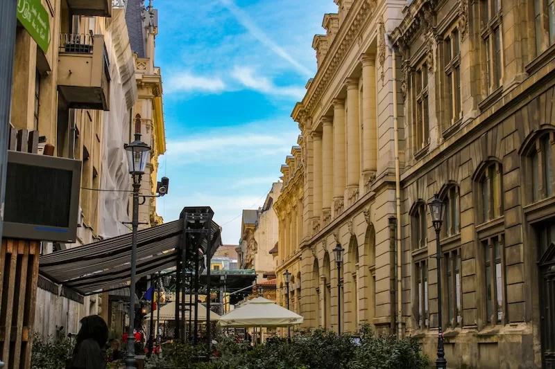 European historic pedestrian street with elegant buildings, outdoor cafes, and street lamps showing affordable city living and walkable neighborhoods