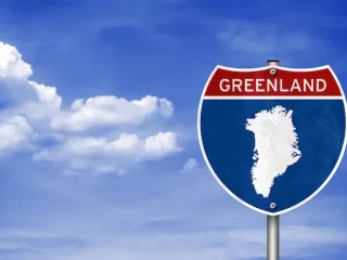A highway sign with an outline of Greenland, symbolizing the geopolitical pressure from the U.S. and its impact on international news and relations.